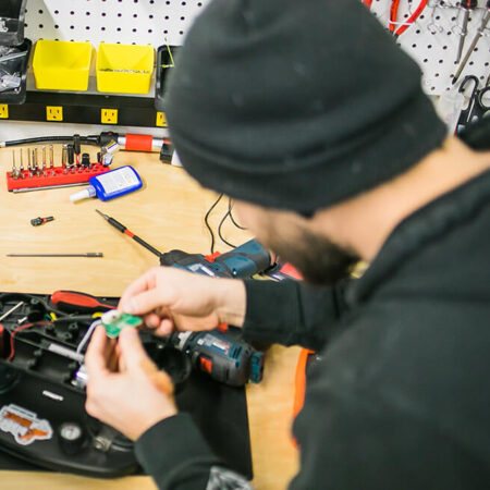 A man at a workshop desk fixing a grabo